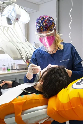 Dentista di ostia della clinica Fam ily Dent mentre cura un dente ad un bambino